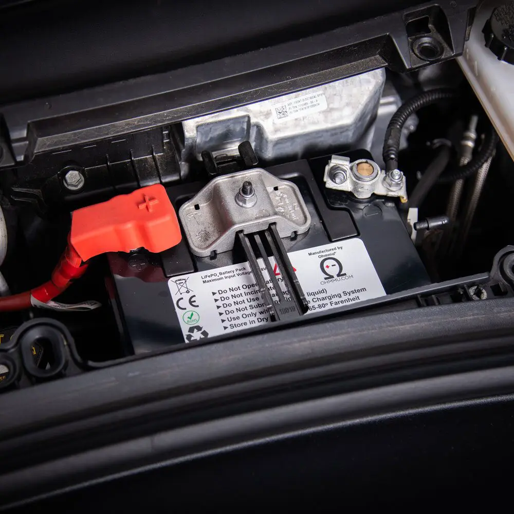 Close-up of an EV's 12V auxiliary battery being serviced by Essential Towing in Vancouver